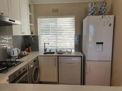 a kitchen with a white refrigerator and a dishwasher at 57 Whale Rock Estate in Hermanus