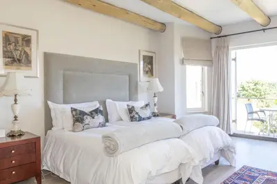 a bedroom with a large bed with white sheets and pillows at 4 Piet Retief in Stellenbosch