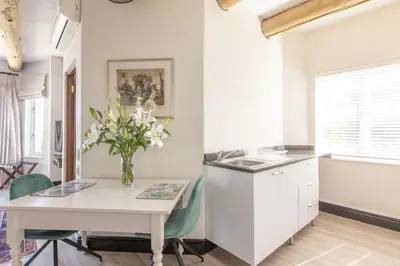 a kitchen with a table and a vase of flowers at 4 Piet Retief in Stellenbosch