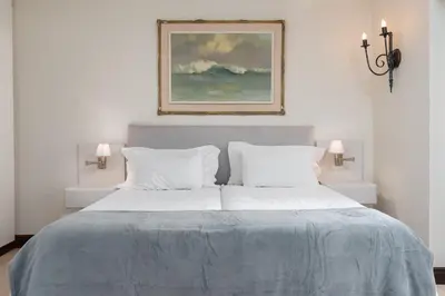 a bedroom with a bed with two pillows and a painting at 4 Piet Retief in Stellenbosch