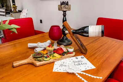 a bottle of wine and a plate of food on a table at La Bonne Auberge in Somerset West