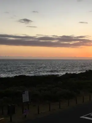 a view of the ocean at sunset from a road at Bungalow by the sea near Cape Town in Kleinmond