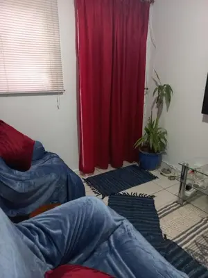 a living room with a red curtain and some rugs at Canberra on Greenwood in Cape Town