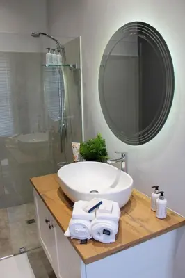a bathroom with a white sink and a mirror at LA RÉVERIE in Franschhoek