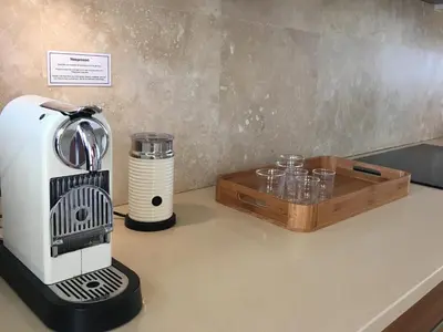 a coffee maker on a counter next to a tray of glasses at 74 on Marine in Hermanus