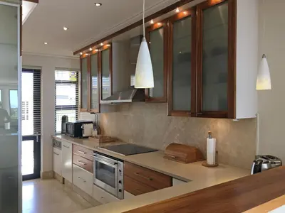 a kitchen with wooden cabinets and stainless steel appliances at 74 on Marine in Hermanus