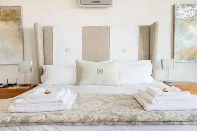 a bedroom with a white bed with towels on it at 74 on Marine in Hermanus