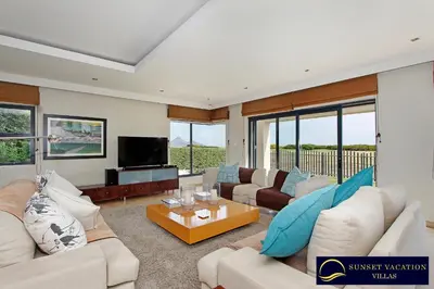 a large living room with couches and a tv at Kite Surfers Beach Villa in Cape Town