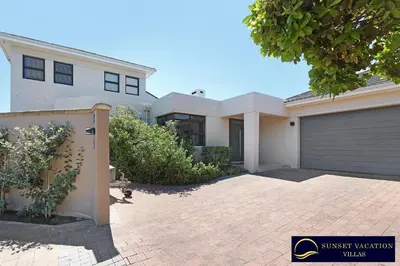 a large white house with a garage at Kite Surfers Beach Villa in Cape Town