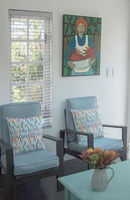 a living room with two chairs and a table at The Yacht in Hermanus