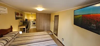 a room with three beds and a flat screen tv at Walters Lane Economy Apartment 1 - No Loadshedding in Cape Town