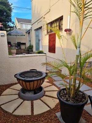 a fire pit in a yard with a plant at Walters Lane Economy Apartment 1 - No Loadshedding in Cape Town