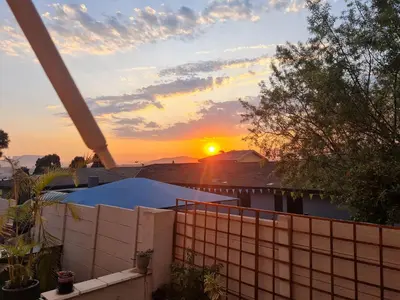 a sunset from the roof of a house at Walters Lane Economy Apartment 1 - No Loadshedding in Cape Town