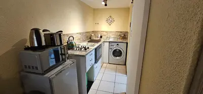 a kitchen with a stove and a washing machine at Walters Lane Economy Apartment 1 - No Loadshedding in Cape Town