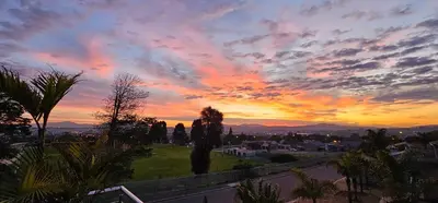a sunset over a city with trees and a street at Walters Lane Economy Apartment 1 - No Loadshedding in Cape Town