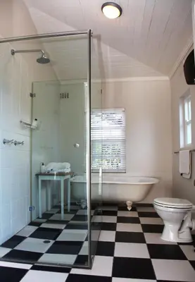 a bathroom with a tub and a toilet and a sink at Verandah House in Hermanus