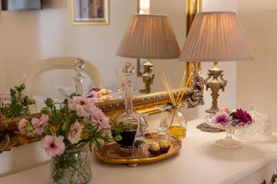 a table with two lamps and flowers on it at Villa Puccini in Cape Town