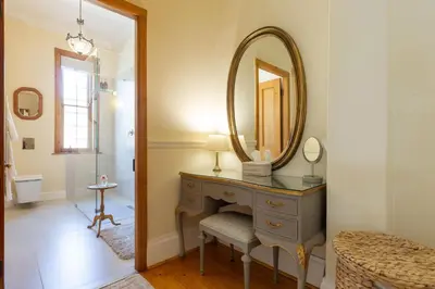 a bathroom with a dressing table and a mirror at Villa Puccini in Cape Town