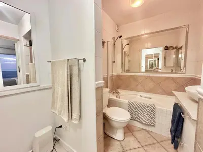 a bathroom with a toilet and a tub and a sink at Seaview Kite Beach Holiday Apartment in Cape Town