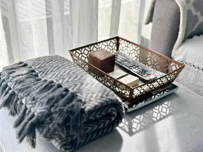 a tray with a remote control on top of a bed at Seaview Kite Beach Holiday Apartment in Cape Town