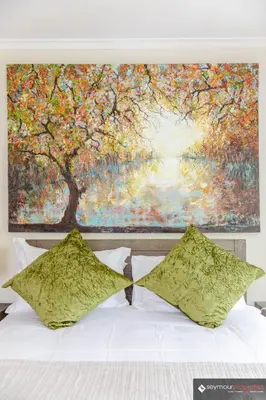 a large painting above a bed with two pillows at CONCORD APARTMENTS Unit 1 in Stellenbosch
