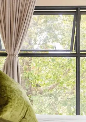 a window with a curtain and a pillow in front of it at CONCORD APARTMENTS Unit 1 in Stellenbosch