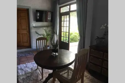 a dining room with a table and chairs and a window at Protea Studio Franschhoek Central in Franschhoek
