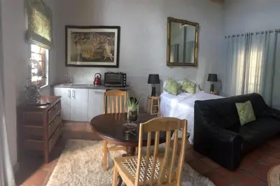 a living room with a bed and a table at Protea Studio Franschhoek Central in Franschhoek
