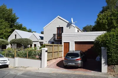 a car parked in front of a white house at Protea Studio Franschhoek Central in Franschhoek