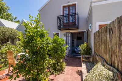 a home with a wooden fence and a yard at Protea Room Franschhoek Central in Franschhoek