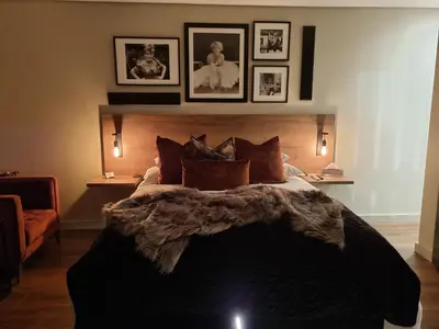 a bedroom with a large bed with pictures on the wall at Vrede Selfcatering in Somerset West