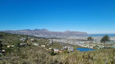 a town on a hill with mountains in the background at Vrede Selfcatering in Somerset West