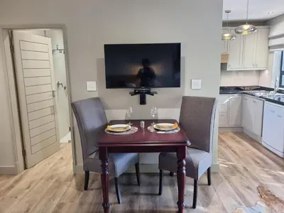 a dining room with a table and chairs in a kitchen at Vrede Selfcatering in Somerset West