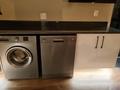 a kitchen with a washing machine and a counter at Vrede Selfcatering in Somerset West