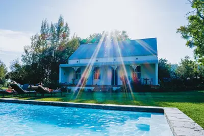 a house with a swimming pool in front of a house at Klein Welmoed Luxury Guest House in Stellenbosch