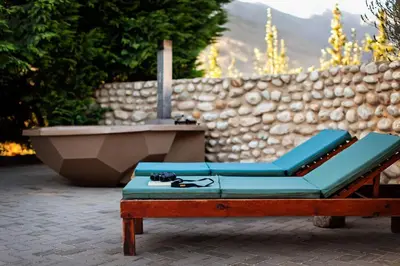 a lounge chair and a tub in front of a stone wall at Vergenoegd in Brandwacht