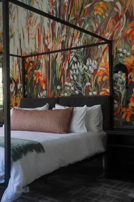 a bedroom with a large bed with a painting on the wall at Hemel 'N Aarde Stud in Hermanus
