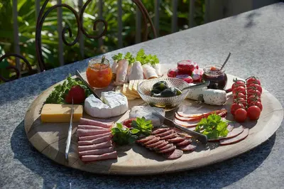 a tray of meats and cheese on a table at Baruch Guest House Rhodes in Stellenbosch