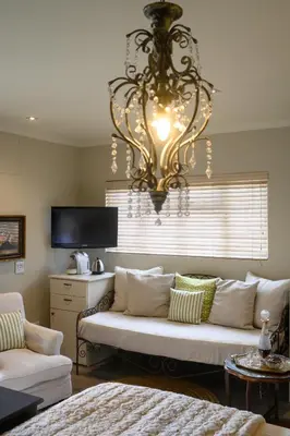 a living room with a couch and a chandelier at Baruch Guest House Rhodes in Stellenbosch