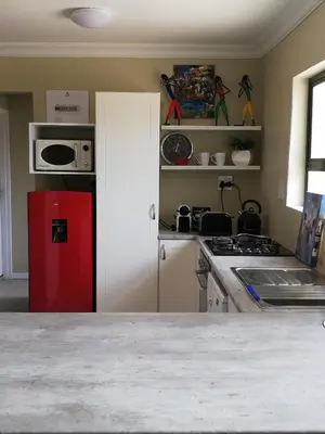 a kitchen with a red refrigerator and a stove at Little Elm Cottage in Cape Town