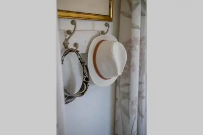 a mirror hanging on a wall in a bathroom at The Amaryllis Luxury Apartment Bella Donna in Bettyʼs Bay