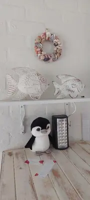 a stuffed penguin under a shelf with a microwave at The Amaryllis Luxury Apartment Bella Donna in Bettyʼs Bay