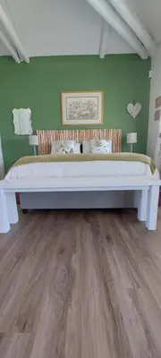 a large bed in a room with green walls at The Amaryllis Luxury Apartment Bella Donna in Bettyʼs Bay
