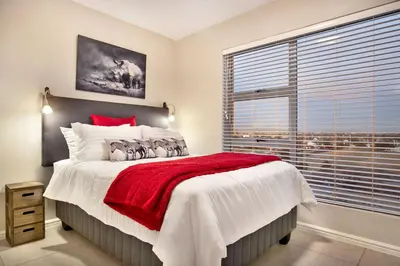 a bedroom with a large bed and a large window at Ocean View A603 in Cape Town