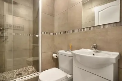 a bathroom with a toilet and a sink and a shower at Ocean View A603 in Cape Town