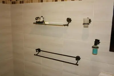 a tiled bathroom with two shelves on a wall at The Vinelands on Alpha Guest House in Cape Town