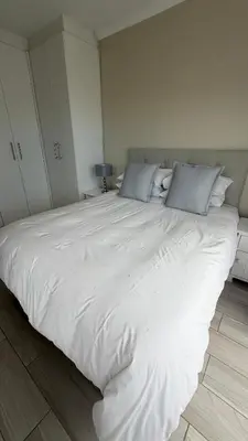 a large white bed with two pillows on top of it at Onrus Holiday Home on Private Estate with Pool in Hermanus