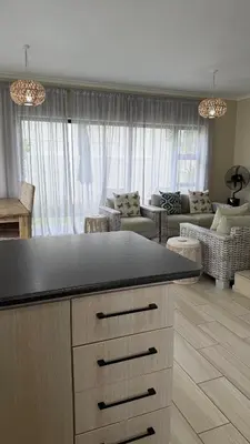 a kitchen with a counter top and a living room at Onrus Holiday Home on Private Estate with Pool in Hermanus