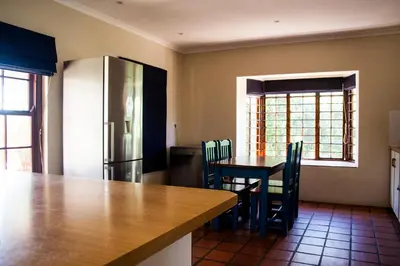 a kitchen with a table and a refrigerator at Hilton House in Pringle Bay