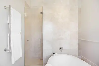 a bathroom with a shower and a white toilet at Banksia Boutique Hotel & Spa in Cape Town